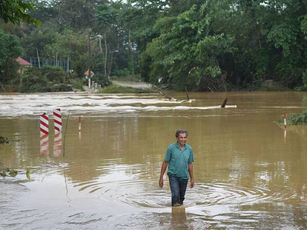 Mangsa banjir Mamat @ Mohd Abdullah, 71, meihat jambatan yang menghubungkan Kampung Air Putih dengan Kampung Teladas yang terputus hubungan ekoran paras air sungai meningkat ketika ditemui hari ini.