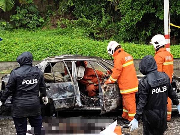 Anggota bomba membantu mengeluarkan mayat mangsa yang rentung dari kereta yang musnah terbakar di kawasan parkir Uptown Teluk Chempedak di sini sebelum diserahkan kepada pihak polis untuk tindakan lanjut, pagi tadi.