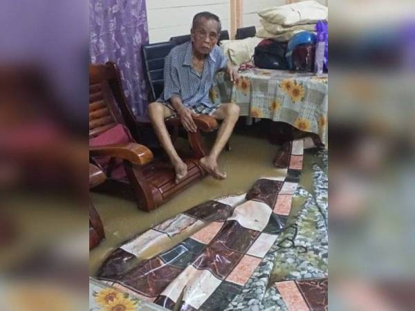 Seorang warga emas melihat keadaan rumahnya di Kampung Sungai Rinting D, Pasir Gudang, dinaiki banjir pada Sabtu lalu.