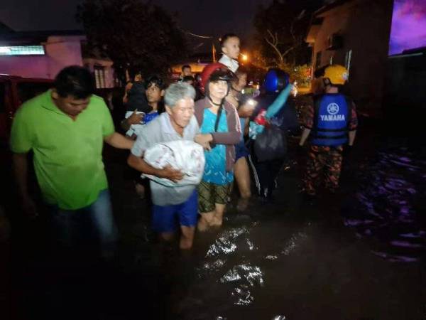 Penduduk di Kampung Ming Terk, Batu Dua, Kulim hari ini dibawa keluar oleh anggota penyelamat ke kawasan selamat. - Foto APM KULIM