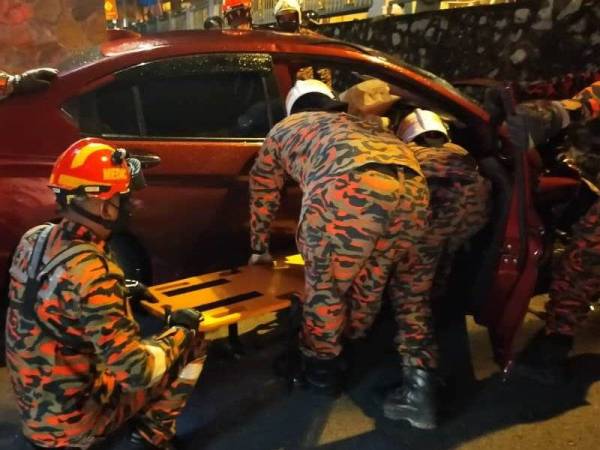 Anggota bomba mengeluarkan seorang warga emas selepas kereta dipandunya melanggar belakang sebuah kereta lain di Kampung Kelantan, Kota Tinggi malam tadi.