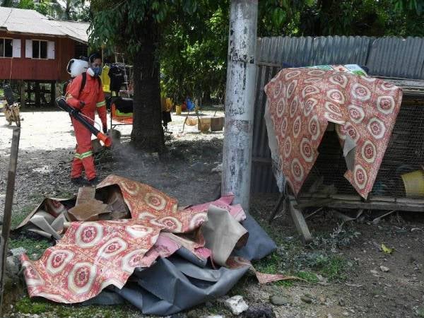 Pembantu Awam Unit Kawalan Vektor, Pejabat Kesihatan Daerah Kemaman, Mohd Faizuddin Dzulkifli melakukan semburan bertujuan untuk kawalan penyakit selepas banjir ketika tinjauan di Kampung Teladas, Air Putih hari ini. Kawalan penyakit dilakukan untuk menghalang haiwan seperti lalat, lipas dan nyamuk membiak di kawasan-kawasan yang dilanda banjir. Kampung tersebut dilanda banjir pada Jumaat lepas dan membabitkan kira-kira 150 buah rumah. - Foto Bernama