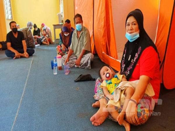 Norizah bersama cucunya, Muhammad Aqif Amshar kini menghuni PPS SK Gual Tok Deh sementara menunggu banjir surut.