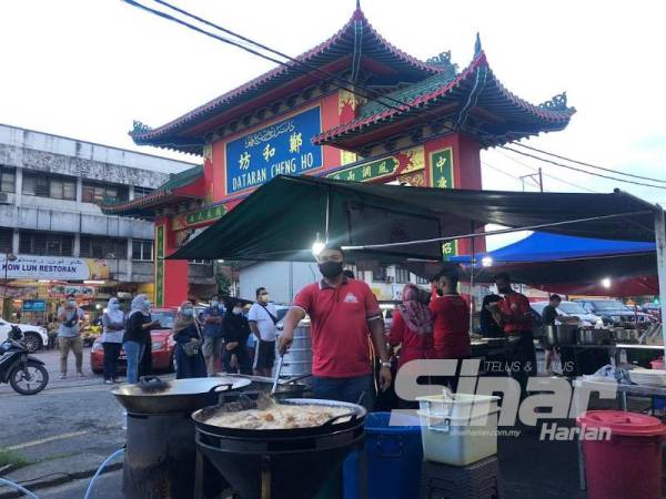 Peniaga nasi kukus di Dataran Cheng Ho, Mohd Kamal Ahmad Zuki, 43, sedang menggoreng ayam yang menjadi antara lauk nasi kukus di sebuah kedai makan di Dataran Cheng Ho.