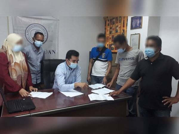 Mohamad Yusrizal (duduk) melihat laporan polis yang telah dibuat oleh mangsa di Pejabat Cake di Alor Setar hari ini.