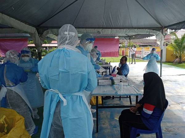 Penduduk sedang menjalani saringan di pekarangan Dewan Masyarakat Taman Meru di sini hari ini.