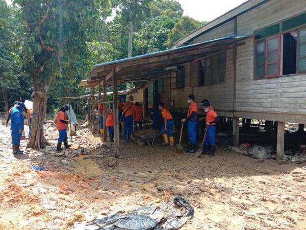 Pasukan APM turun padang membantu membersihkan rumah penduduk di Air Putih yang dipenuhi lumpur selepas banjir surut. -Foto: Ihsan APM