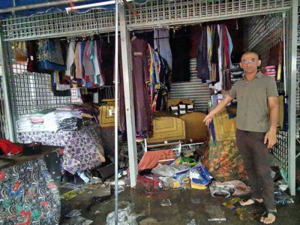 Arif menunjukkan antara barangan di premis miliknya yang rosak akibat ditenggelami air dalam kejadian banjir di Kuala Terengganu malam tadi.