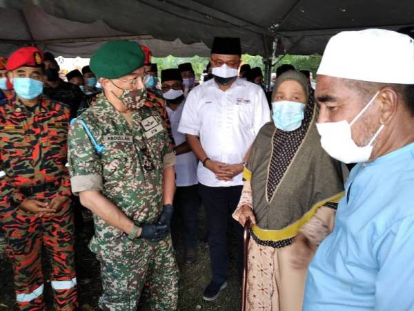 Al-Sultan Abdullah menyampaikan kata-kata semangat kepada Hamka (kanan) dan isterinya, Rohaya Ismail, 56, berikutan kejadian yang menimpa anak bongsu pasangan itu, Loqman yang masih belum ditemui.