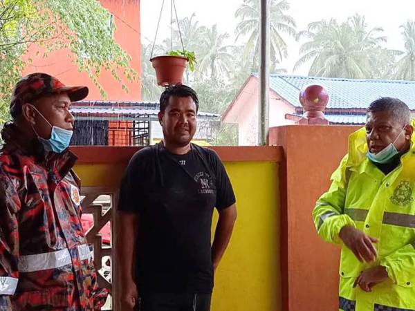 Ab Rashid (kanan) menasihatkan penduduk supaya berpindah ke PPS sekiranya air naik ekoran hujan lebat tanpa henti yang sedang melanda kawasan ini sejak malam tadi.