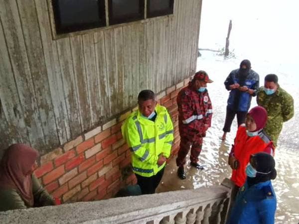 Ab Rashid (dua dari kiri) bersama agensi penyelamat Jajahan Tumpat bertemu dengan penduduk di Kampung Kubang Sawa hari ini bertanyakan khabar mereka selepas kecoh isu penduduk kampung enggan pindah bimbang rumah dipecah masuk pencuri.