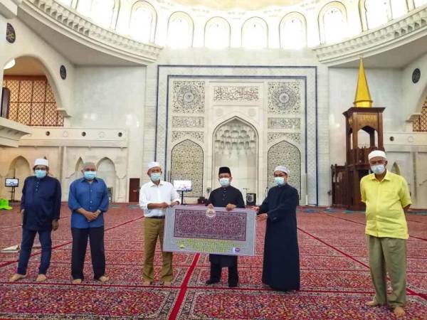 Gimik penyerahan karpet disampaikan oleh Pengerusi Persatuan Sahabat Masjid Wilayah Persekutuan, Datuk Seri Hasan Arifin (tiga dari kiri) kepada Mohd Ajib (tiga dari kanan) di Masjid Wilayah Persekutuan hari ini.
