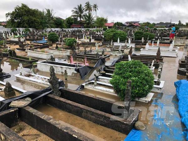 Air yang masih bertakung di dalam kawasan Tanah Perkuburan Islam Kubur Dato, Tumpat menenggelamkan belindan dan batu nisan akibat hujan lebat selama dua hari sejak kelmarin.