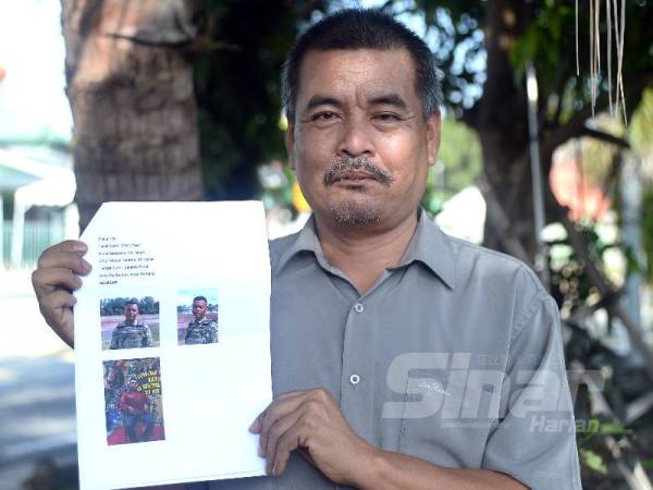 Jamaludin menunjukkan gambar anaknya, Mohamad Amirul Hafizzudin yang turut mengikut jejak langkahnya menjadi anggota tentera.- FOTO ROSLI TALIB