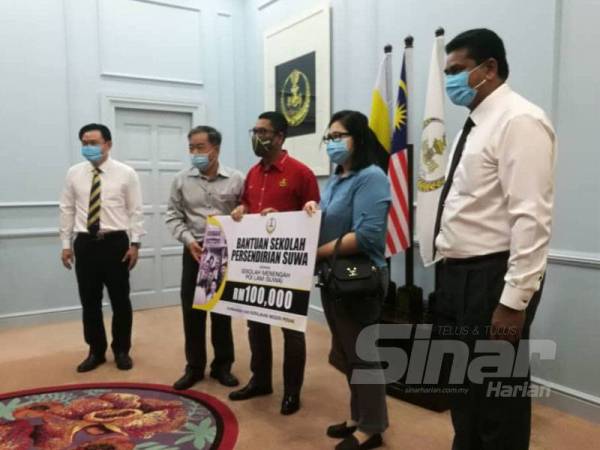 Ahmad Faizal (tengah) menyampaikan sumbangan kepada sekolah SUWA di Pejabat Menteri Besar Perak, Bangunan Perak Darul Ridzuan, Ipoh hari ini.