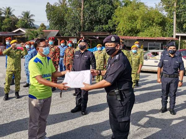 Ketua Polis Daerah Ipoh, Asisten Komisioner A Asmadi Abdul Aziz menyerahkan kain rentang kepada Meor Hezbullah simbolik tamatnya tugas PKPD di Taman Meru 2C hari ini.
