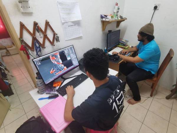 Kedua-dua beradik ini saling bertukar pandangan ketika berkarya.