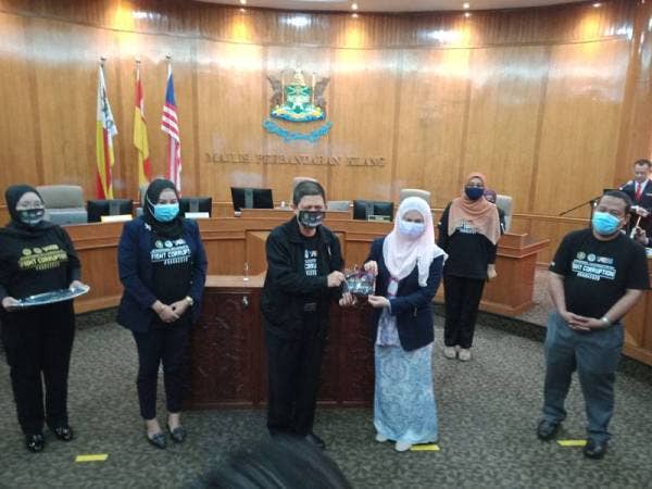 Abdul Razak (tiga dari kiri) menyampaikan pelitup muka kepada warga kerja MPK selepas Majlis Pelancaran Sambutan Hari Anti Rasuah Antarabangsa (HARA) PBT Perangi Rasuah peringkat MPK di Dewan Raja Mahadi, Klang hari ini.