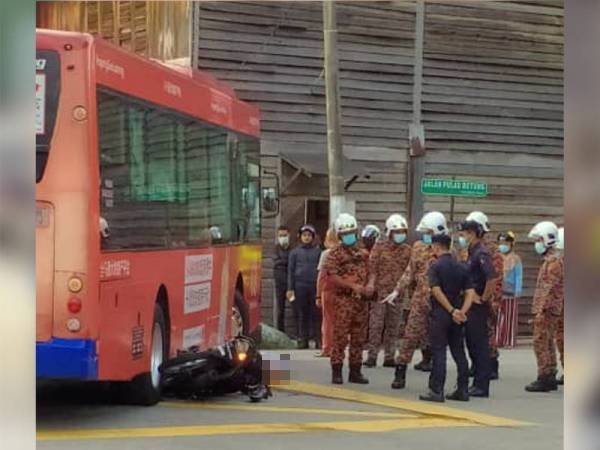 Anggota bomba membantu mengeluarkan mangsa yang tersepit di bawah bas dalam kejadian di Jalan Sungai Nipah pagi tadi.