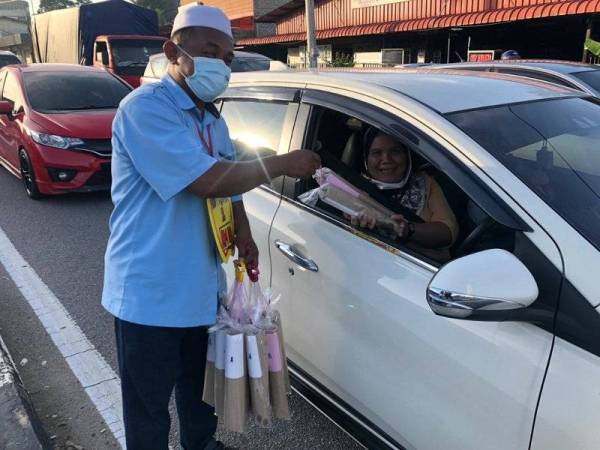 Tidak lokek dengan senyuman antara menarik minat pengguna jalan raya membeli roti john yang dijual Noor Azli di lampu isyarat Cherang, Kota Bharu.