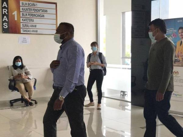 Yugeswaran (kiri) hadir ke Mahkamah Majistret Tapah hari ini untuk pertuduhan memandu dalam keadaan mabuk.