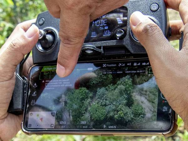 Pengarah Jabatan Perhutanan Kelantan, Abdul Khalim Abu Samah melihat pemandangan dari udara yang diambil menggunakan dron milik Jabatannya bagi memantau aktiviti pencerobohan hutan di Hutan Simpan Kekal (HSK) Chabang Tongkat, hari ini. - Foto Bernama
