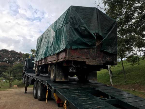 Lori yang dinaiki dua lelaki membawa muatan kayu balak secara haram dirampas untuk siasatan lanjut. Foto: Ihsan Jabatan Perhutanan Perak. 