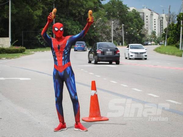 Muhammad Effendi memakai kostum spiderman untuk menarik orang ramai membeli pati teh aisnya.