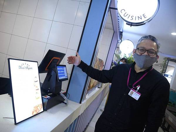 Ketua Pegawai Sumber Manusia dan Pengarah Komunikasi Korporat Aeon Co (M) Bhd, Dr Kasuma Satria menunjukkan sebuah gerai yang menggunakan aplikasi bagi memesan makanan sempena pembukaan Medan Selera Aeon Big Wangsa Maju hari ini.