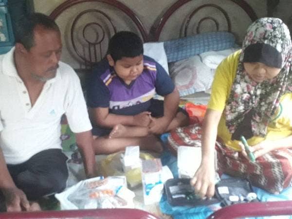 Jaafar dan Muhammad Iman Nabihan melihat ubat dan jarum insulin yang perlu diambil dan digunakan oleh Sarina pada setiap hari.