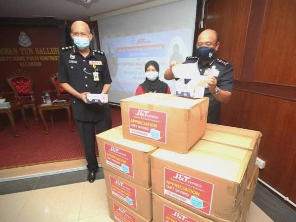 Penyerahan sumbangan 200,000 pelitup muka oleh J&T Express yang disampaikan wakil syarikat, Nur Fateen Aisyah Ibrahim (tengah) kepada Shafien di IPK negeri di Kota Bharu hari ini.