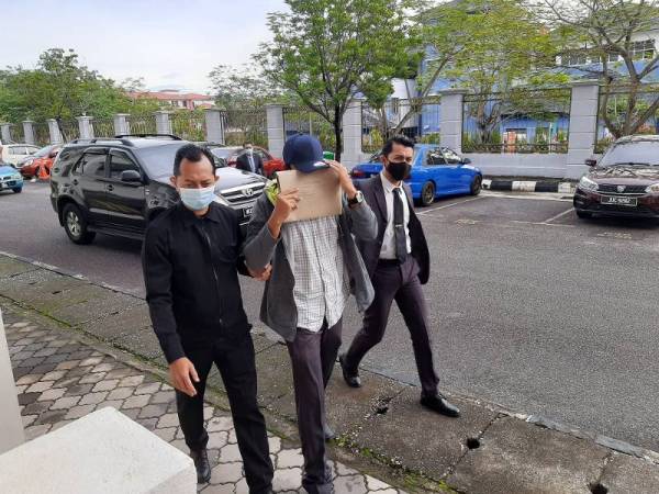 Tertuduh (tengah) dibawa ke Mahkamah Sesyen Seremban hari ini.