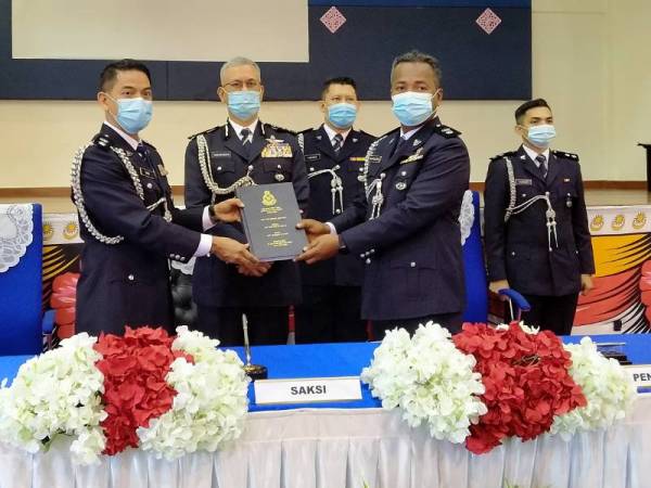 Syed Basri (kiri) melakukan serah tugas kepada Ketua Polis Daerah Baling yang baharu, Superintendan Shamsudin Mamat sambil disaksikan Hasanuddin (dua kiri).