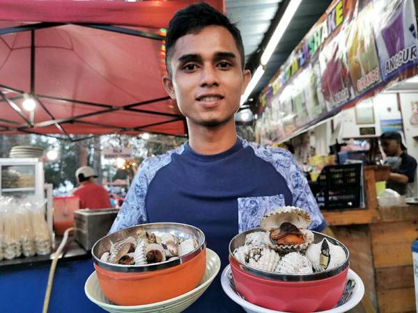 Pembantu kedai di gerai Penyu Corner, Mohamad Nazariezal Arif Daud menunjukkan antara kerang gasi yang siap dimasak dan sedia untuk dihidangkan kepada pelanggan.