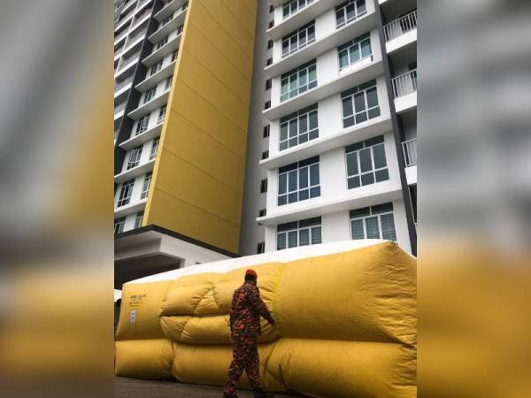 Anggota bomba memasang 'air cushion' sebagai persediaan sekiranya seorang wanita terbabit nekad terjun dari tingkat 10 di Apartment Twin Danga Residence, Kampung Sungai Danga, Johor Bahru hari ini.