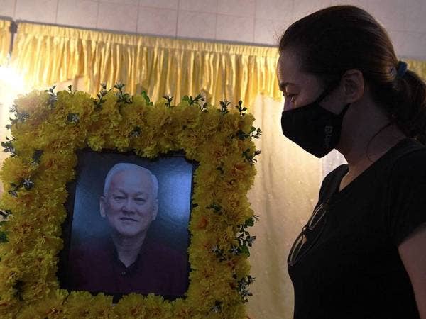 Moey Mi Lin, 45, merenung gambar mendiang bapanya Moey Yoke Ham iaitu bekas Ketua Jurulatih Skuad Juara Liga Perdana 1 Pulau Pinang 1998 yang meninggal dunia di Hospital Pulau Pinang hari ini. - Foto Bernama