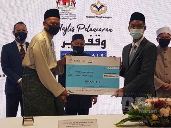 Pengerusi SPAN, Wan Hassan Mohd Ramli (depan, kiri) menyerahkan sumbangan wakaf berjumlah RM2 juta kepada Amir pada Majlis Pelancaran Wakaf Air.
