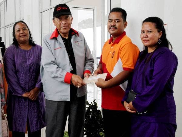 Ahli Lembaga Pemegang Amanah Yayasan Pengaman Malaysia Datuk Kamaruddin Mat Desa (dua dari kiri) menyampaikan sumbangan kebajikan kepada Sarjan Norihan Tari, 39, (dua,kanan) yang cedera dan Relow Ko, 48, (kiri) balu kepada mendiang Sarjan Baharuddin Ramli yang terkorban selepas berbalas tembakan dengan sekumpulan penyeludup di sempadan Malaysia-Thailand pada bulan lalu di Batalion 3 Pasukan Gerakan Am, Bidor hari ini. - Foto Bernama