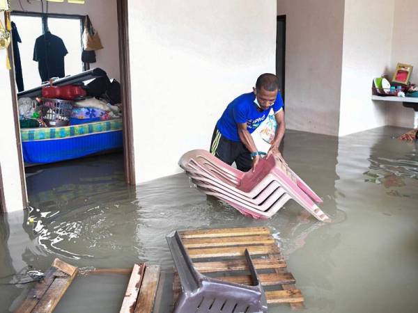 Mangsa banjir Mohd Azlan Samsudin, 37, mengangkat kerusi selepas rumahnya ditenggelami banjir ketika tinjauan di Program Perumahan Rakyat Termiskin (PPRT) Kampung Baru Kemasik, hari ini. Jumlah mangsa banjir di Terengganu menyaksikan peningkatan mendadak kepada 4,094 orang daripada 996 keluarga setakat 7 pagi ini, berbanding 972 orang daripada 246 keluarga pada 4.30 petang pada Jumaat. - --fotoBERNAMA
