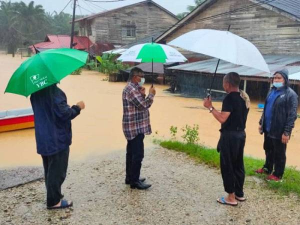 Exco Kebajikan, Pembangunan Wanita, Keluarga dan Perpaduan Nasional Terengganu, Hanafiah Mat (dua dari kiri) meninjau keadaan banjir di sekitar Kemaman.