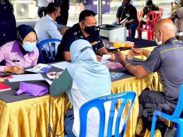 Mohd Rosli (kanan) semasa turun padang bertemu orang ramai yang datang untuk membayar saman.