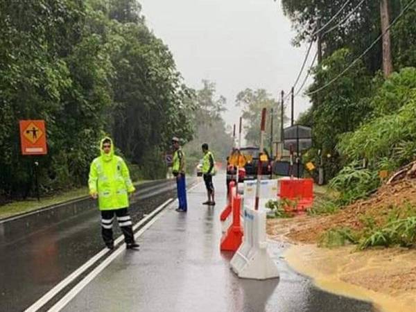 Polis memantau keadaan jalan bagi memastikan ia selamat dilalui kenderaan. -Foto ihsan polis