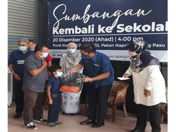Mohd Radzi (dua dari kanan) semasa menyempurnakan Majlis Penyampaian Sumbangan Kembali Ke Sekolah Peringkat Parlimen Kubang Pasu di Pusat Khidmat Ahli Dewan Undangan Negeri (ADUN) Bukit Kayu Hitam di Napoh pada Ahad. Turut hadir Halimaton Shaadiah (kanan).