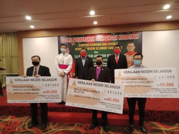 Amirudin bersama penerima sumbangan ketika Majlis Penyerahan Sumbangan Kebajikan Sempena Perayaan Krismas Peringkat Negeri Selangor di Dewan Jubli Perak, Bangunan Sultan Salahuddin Abdul Aziz Shah di sini pada Isnin.