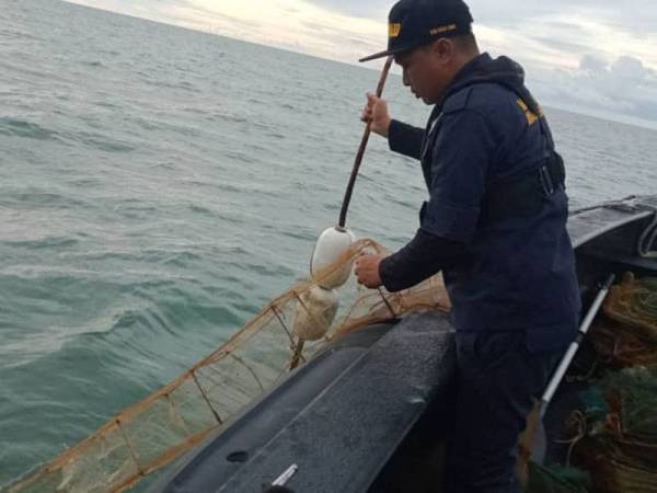 Anggota Maritim merampas bubu naga yang dipasang secara haram di sekitar Pulau Pasir Hitam, Taiping. - Foto ihsan Maritim Malaysia