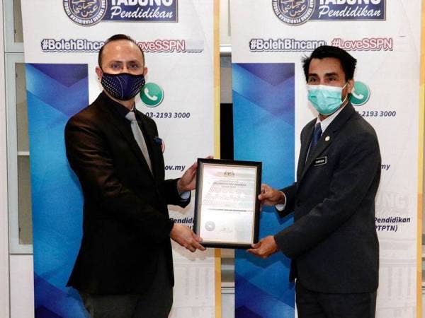 Ahmad Dasuki (kiri) menerima Sijil AKKP Tahun 2019 daripada Syarifuddin dalam satu kenyataan yang dikeluarkan PTPTN pada Isnin.