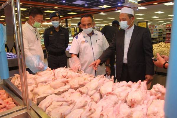 Adnan (dua dari kanan) bersama Saiful Adli (kanan) membuat pemeriksaan harga terhadap barangan tersenarai di bawah harga kawalan yang dijual di Pantai Timor Hypermarket Sdn Bhd Pengkalan Chepa pada Selasa.