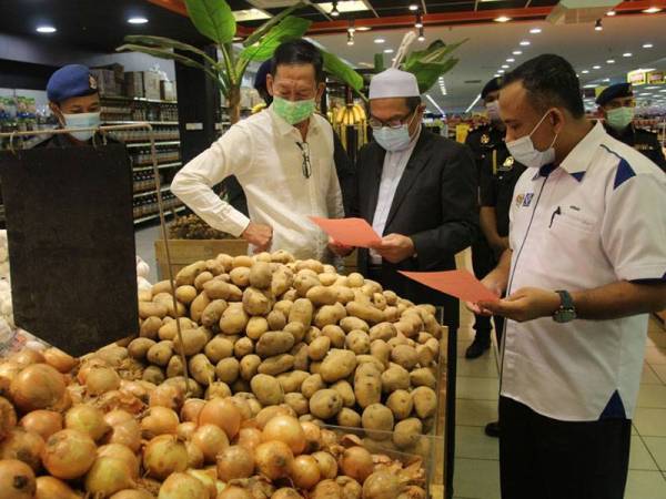 Adnan (kanan) ketika melakukan pemeriksaan harga barangan terkawal di Pantai Timor Hypermarket Sdn Bhd Pengkalan Chepa sempena pelancaran SHMMP pada Selasa.