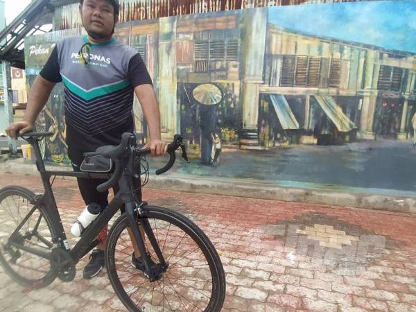 Hishamudin merakamkan gambar kenangan bersama lukisan tradisional Pekan Melayu dan Pekan Cina di Medan Seni Alor Setar di Alor Setar pada Ahad.