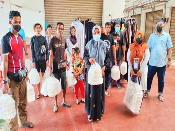 Kak Zah (tiga,kanan di hadapan) bersama sukarelawan Dapur Darurat Kak Zah bersiap sedia untuk mengagihkan makanan kepada mangsa banjir yang terkandas di sekitar Rantau Panjang.